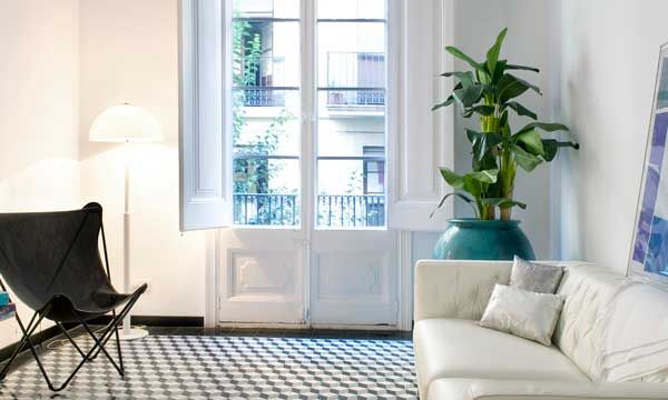 Un universo blanco, donde la pared actúa como pantalla de proyección. Sofá de Bianca Bosman y sillón Acapulco.
