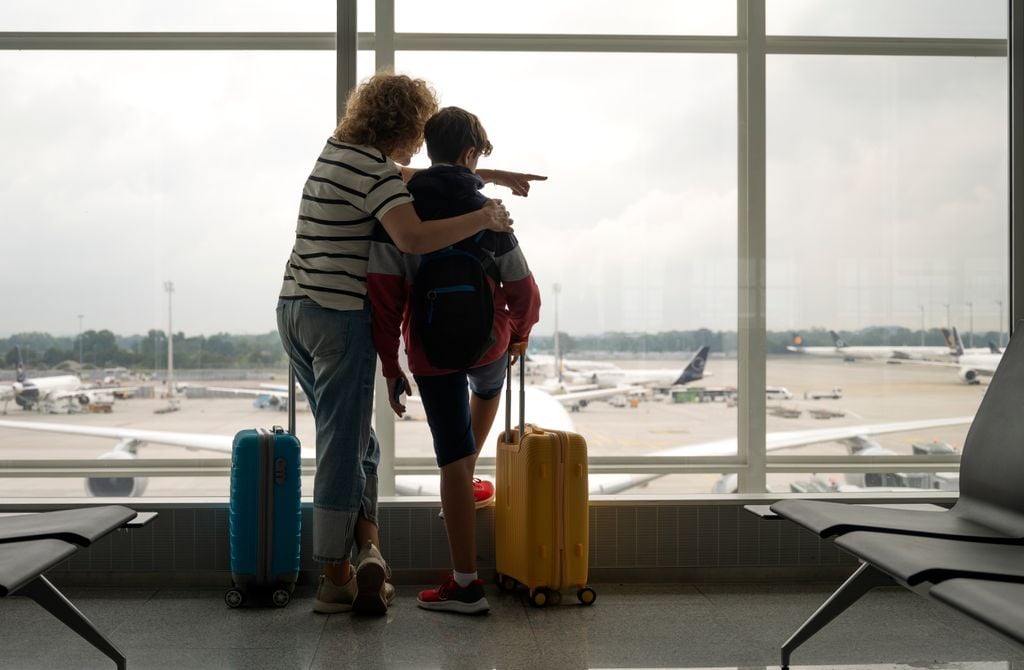 Madre despidiéndose de su hijo en el aeropuerto que va a estudiar en el extranjero