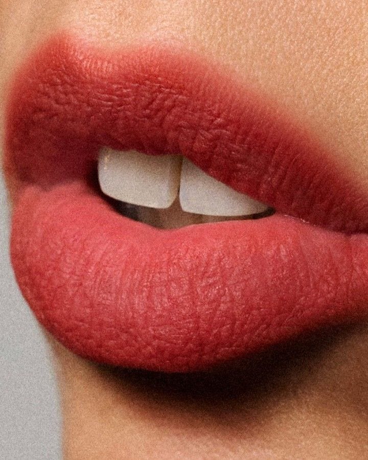 Labios con labial rojo efecto mate derretido, textura suave y contornos difuminados.