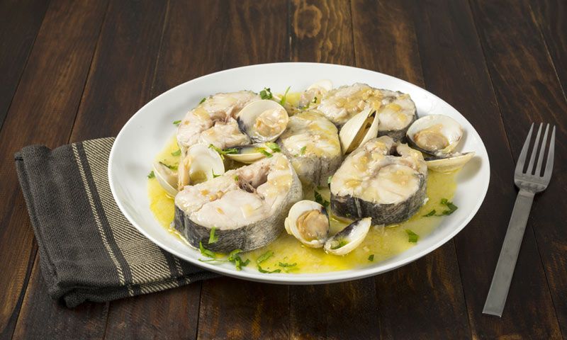 Otra de las formas más populares de cocinar la merluza es con almejas.