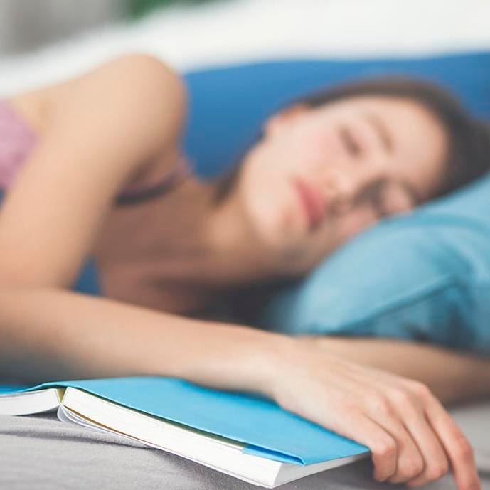 Mujer dormida con libro en la mano