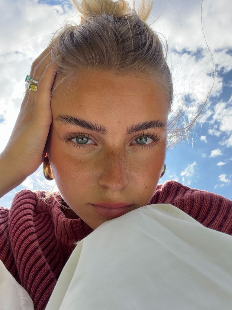 Lea Breuer en primer plano con moño, pecas y maquillaje natural