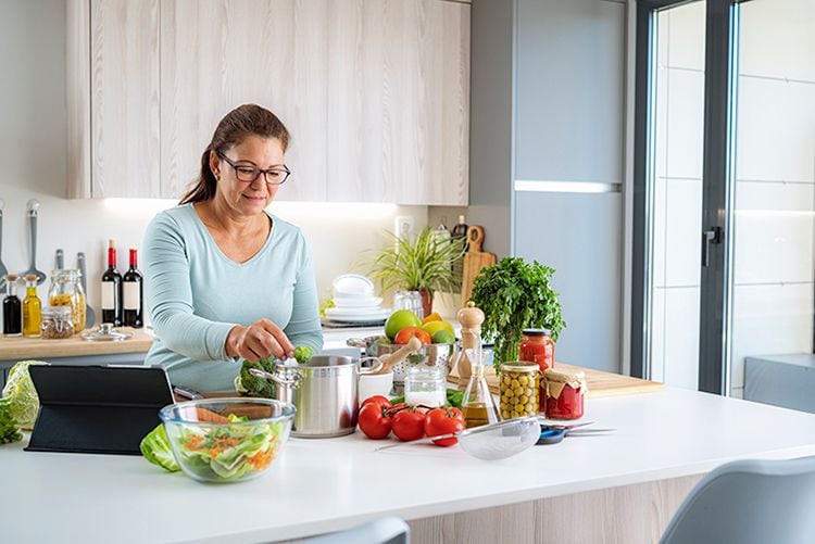 Mujer madura preparando unas verduras saludables
