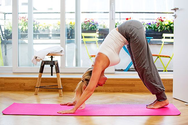 Mujer haciendo yoga en casa
