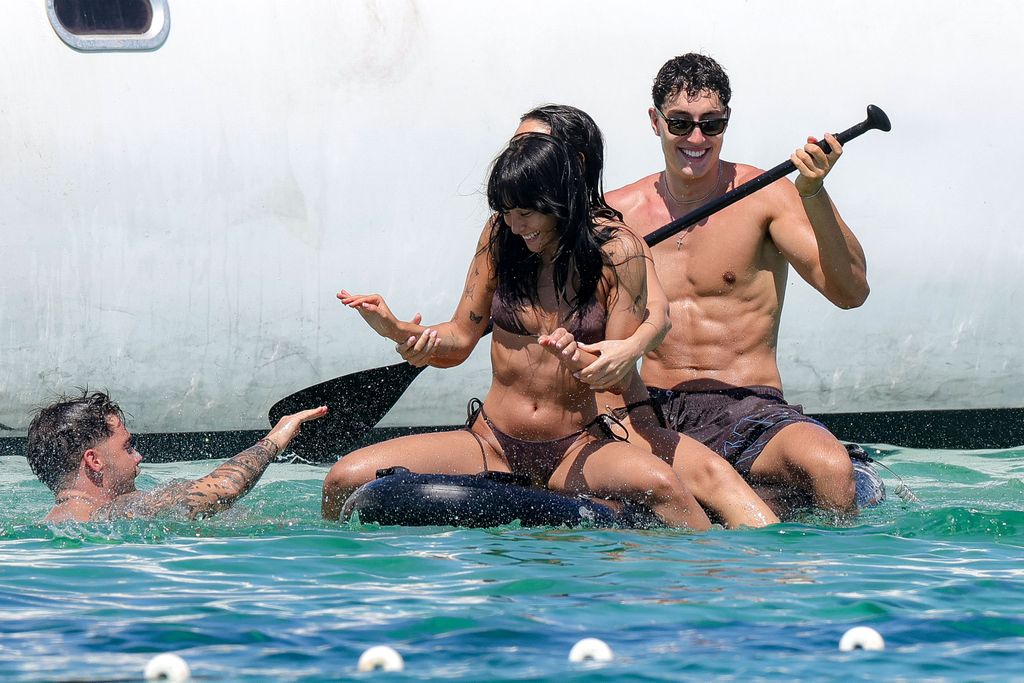Aitana y Plex en una tabla de paddle surf con amigos