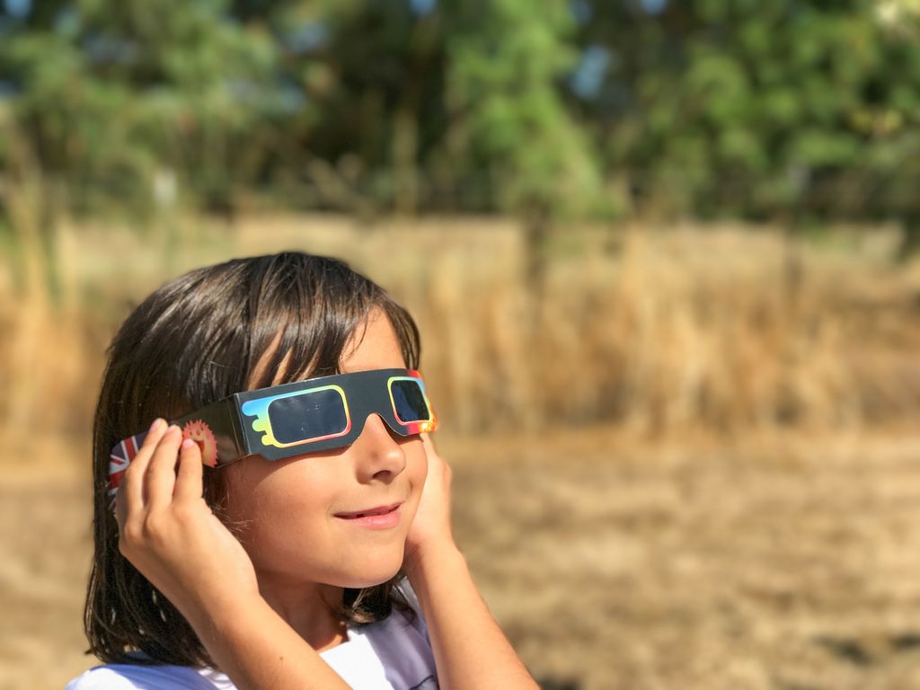 niña con unas gafas homologadas para ver el eclipse 