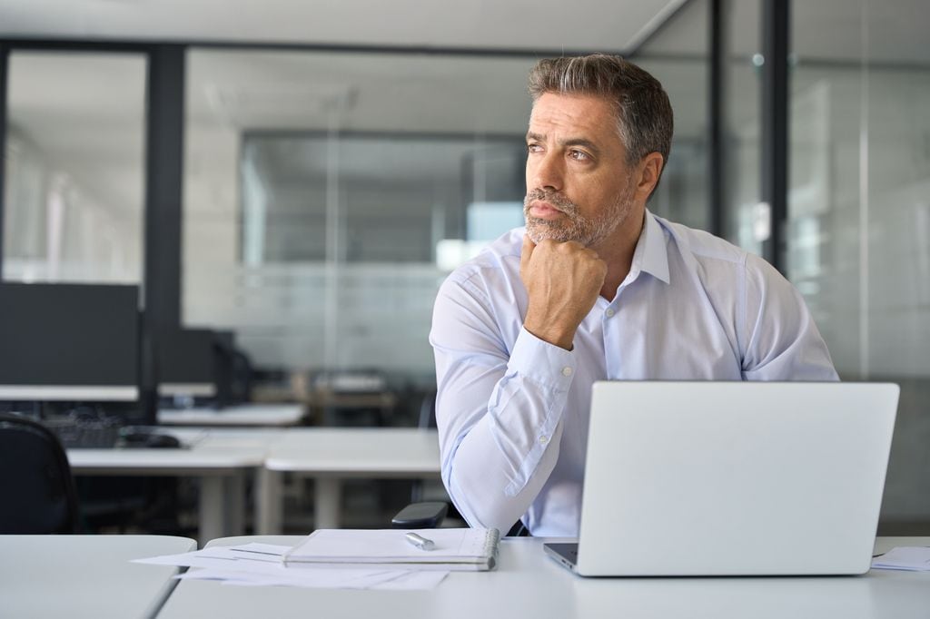 Hombre trabajando en actitud pensativa y triste