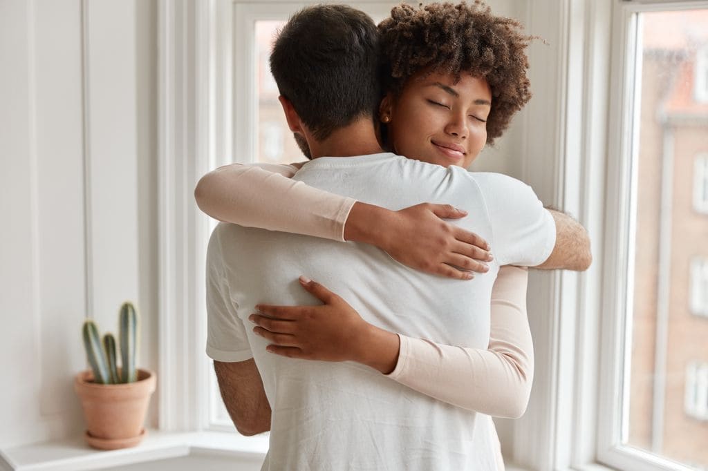 Pareja abrazándose en su casa