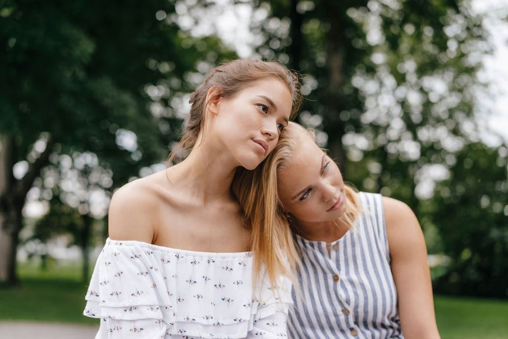 Mujer apoyada en el hombro de su amiga