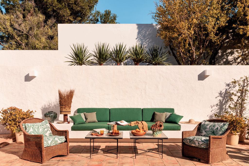 Terraza con banco de obra y sillones de mimbre