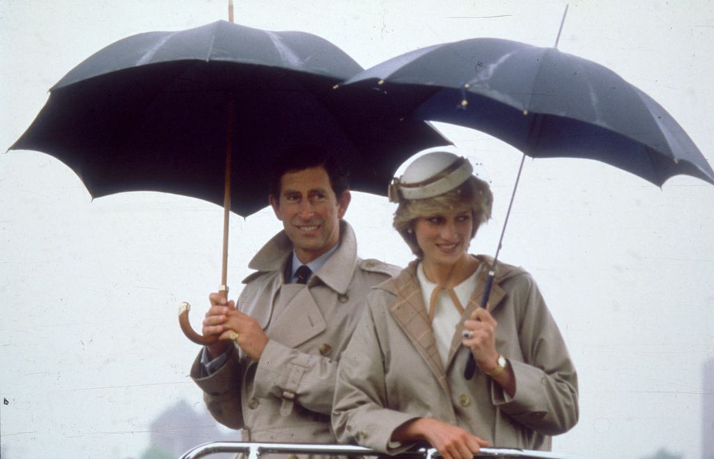 La princesa Diana y el entonces príncipe Carlos, con paraguas, en un viaje a Nueva Zelanda.