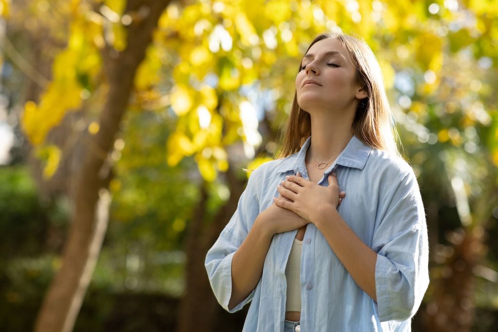 mujer con las manos en el pecho, respirando