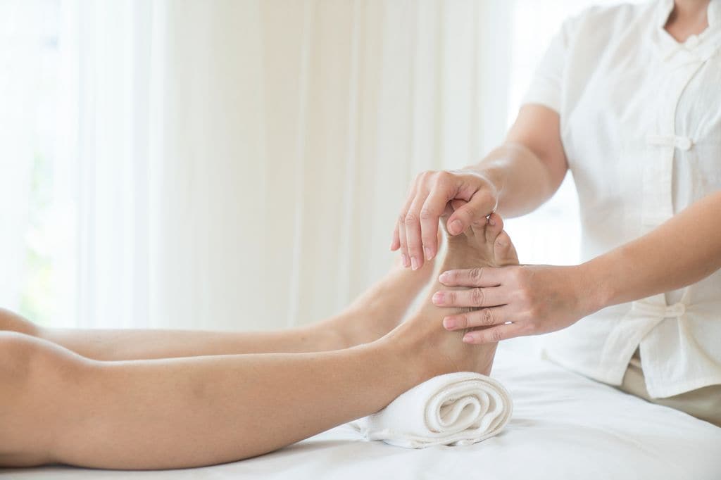 mujer recibiendo un masaje en los pies