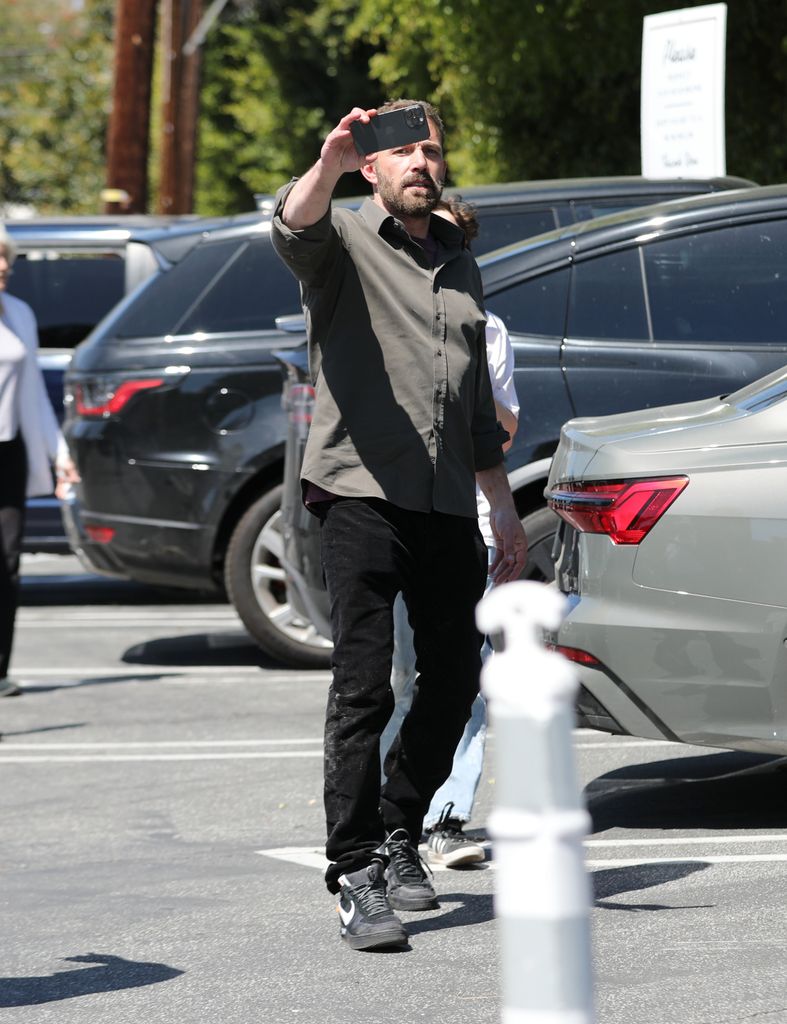 Ben Affleck reaccionó a la presencia de paparazzi siguiendo sus movimientos sacando su teléfono móvil para grabarlos.