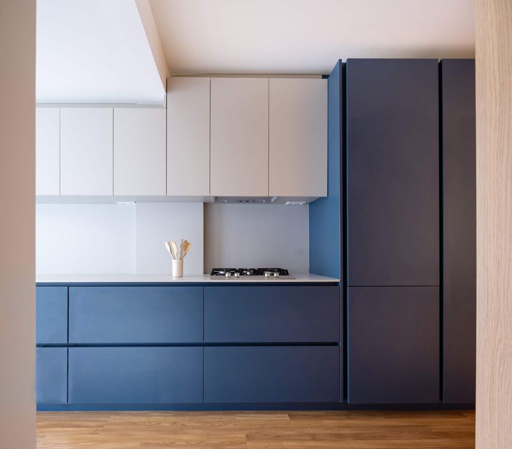 Cocina con muebles en dos tonalidades: oscura en los módulos bajos y blanco en los altos
