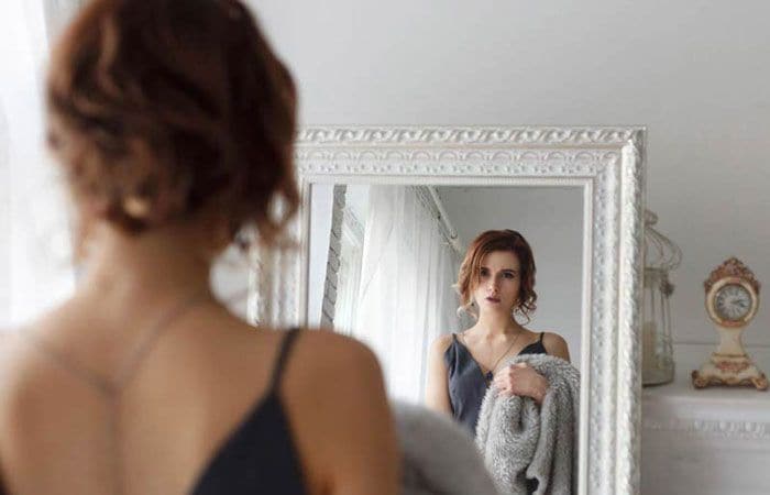 Mujer se mira al espejo