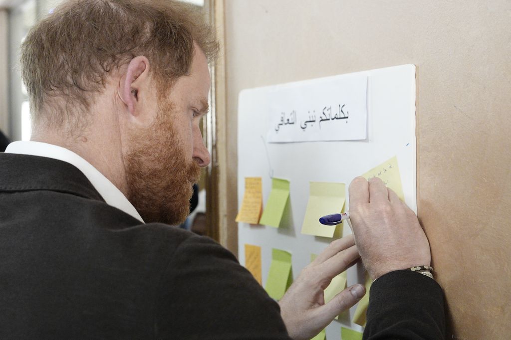 El príncipe Harry, escribiendo su mensaje 