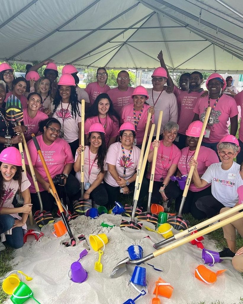 Plano entero de Gisele Bündchen posando con algunas trabajadoras y voluntarias