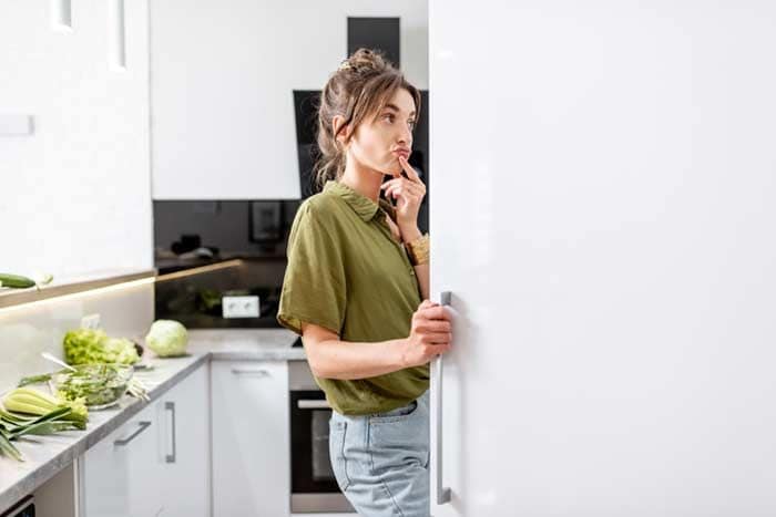 mujer buscando comida en la nevera