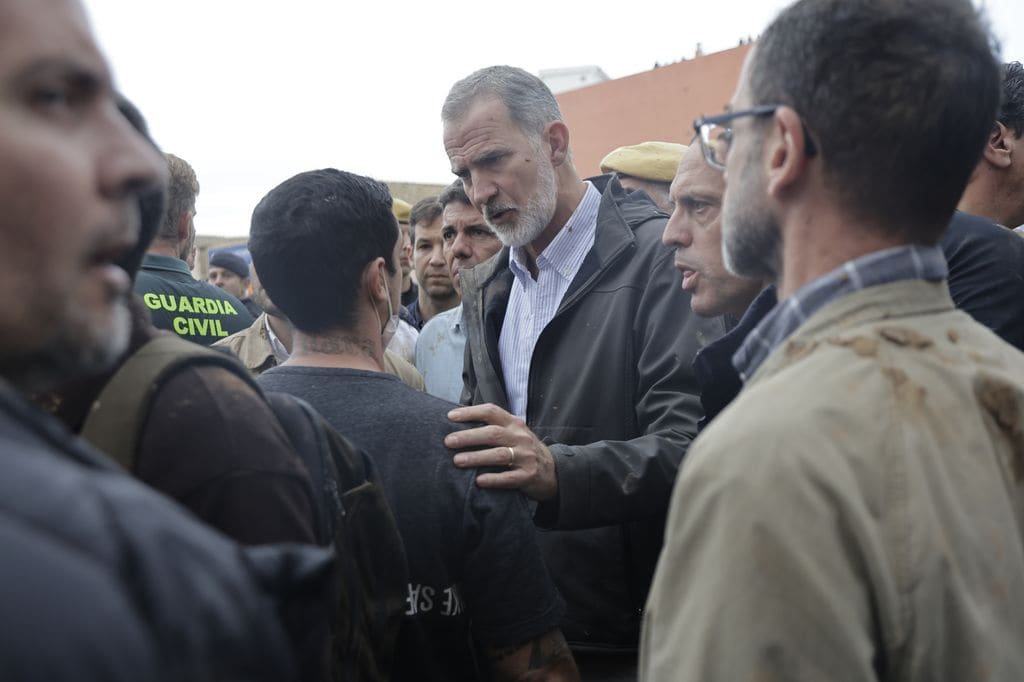 Plano medio del Rey Felipe hablando con un vecino afectado por la DANA en Valencia
