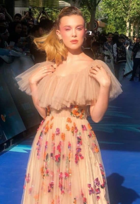 Millie Bobby Brown con cabello rubio miel, cola alta y vestido de Valentino