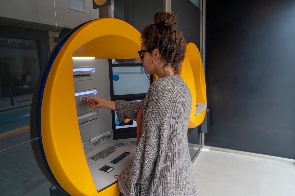 Mujer sacando dinero de un cajero 