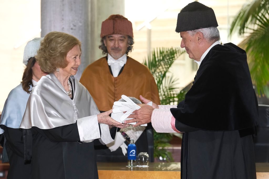 La reina Sofía junto al rector Lluis Serra, quien le entrega el birrete, símbolo de la sabiduría
