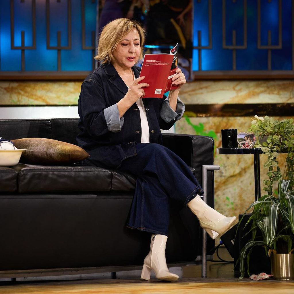 Plano entero de Carmen Machi en la Revuelta sentada leyendo un libro
