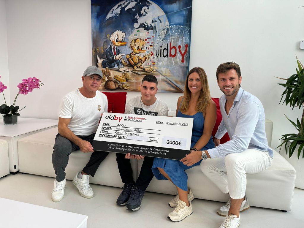Toni Company posando con un cheque de una donación