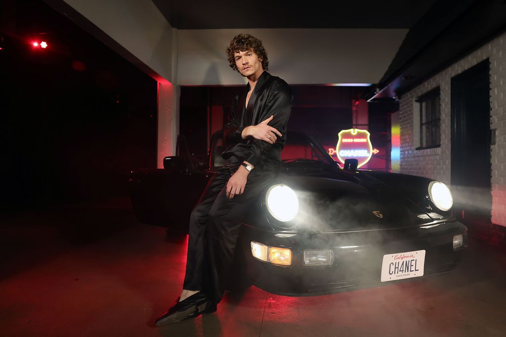 Connor Storrie posa junto a un deportivo brandeado. 