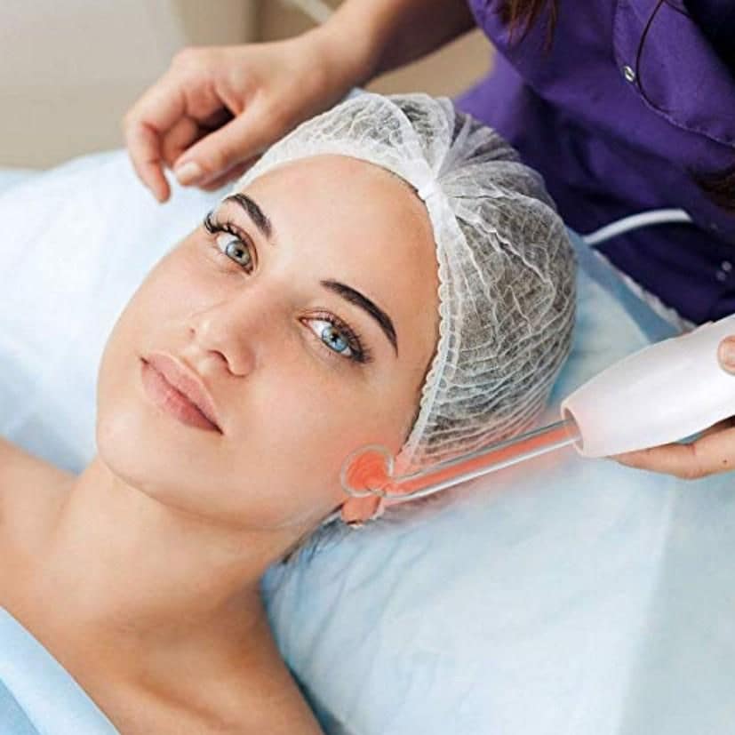 Mujer a la que le aplican el TSEMY Portable High Frequency Wand Handheld Skin massager for Body & Facial Care