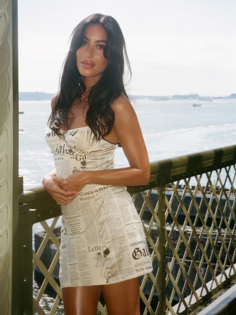 Inés de Ramón con vestido de periódico en un balcón