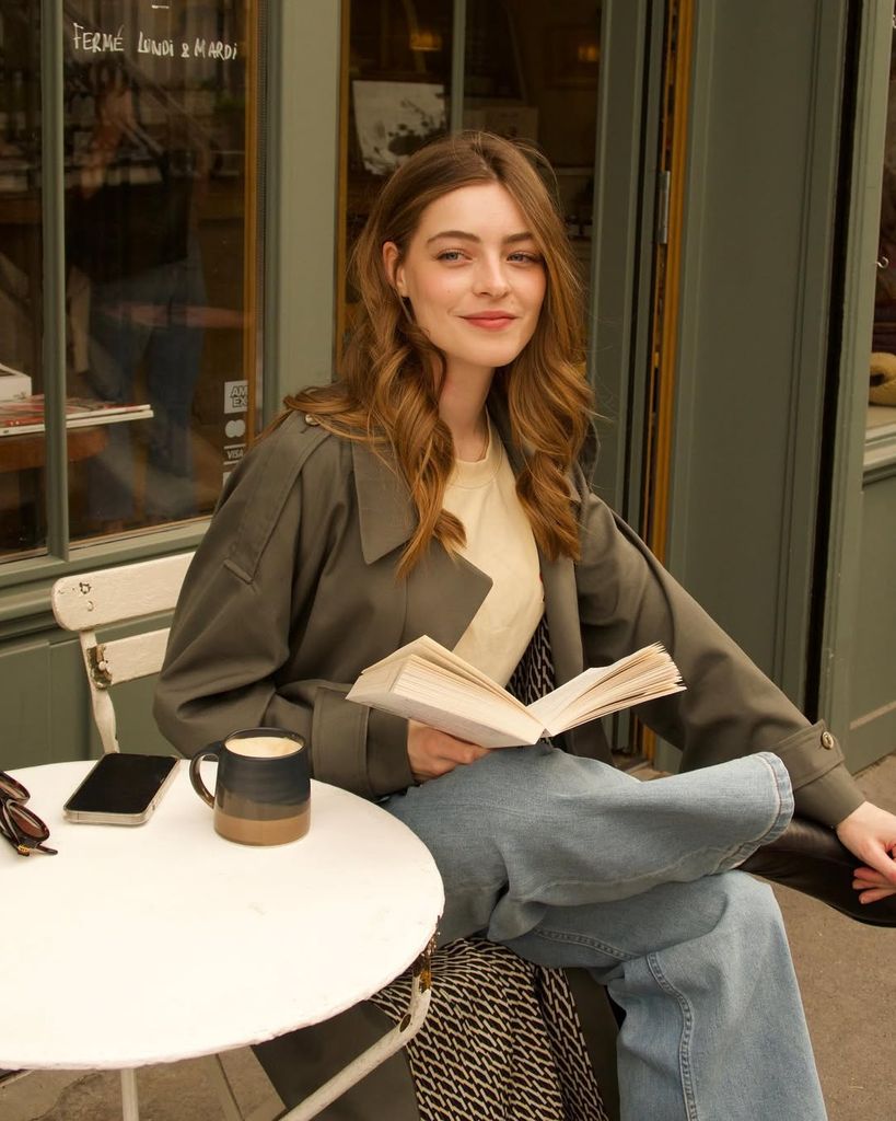 Una chica penando con un libro en una terraza