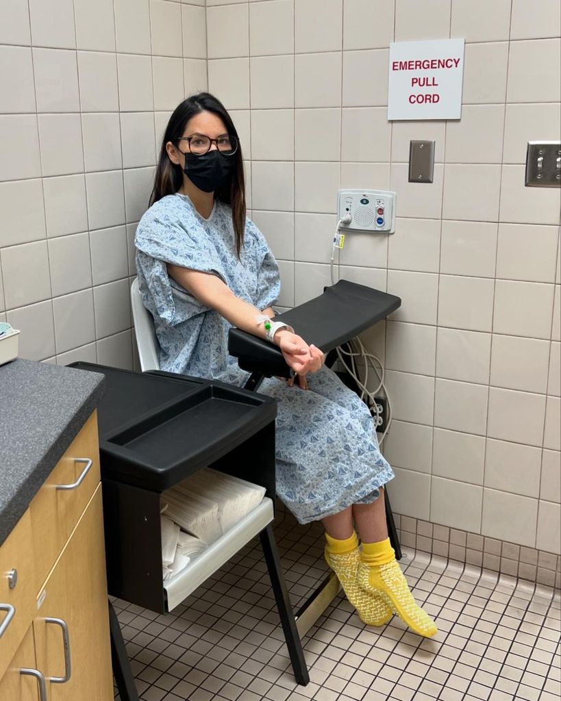 Plano medio de Olivia Munn en un hospital haciéndose tratamientos para su cáncer de mama