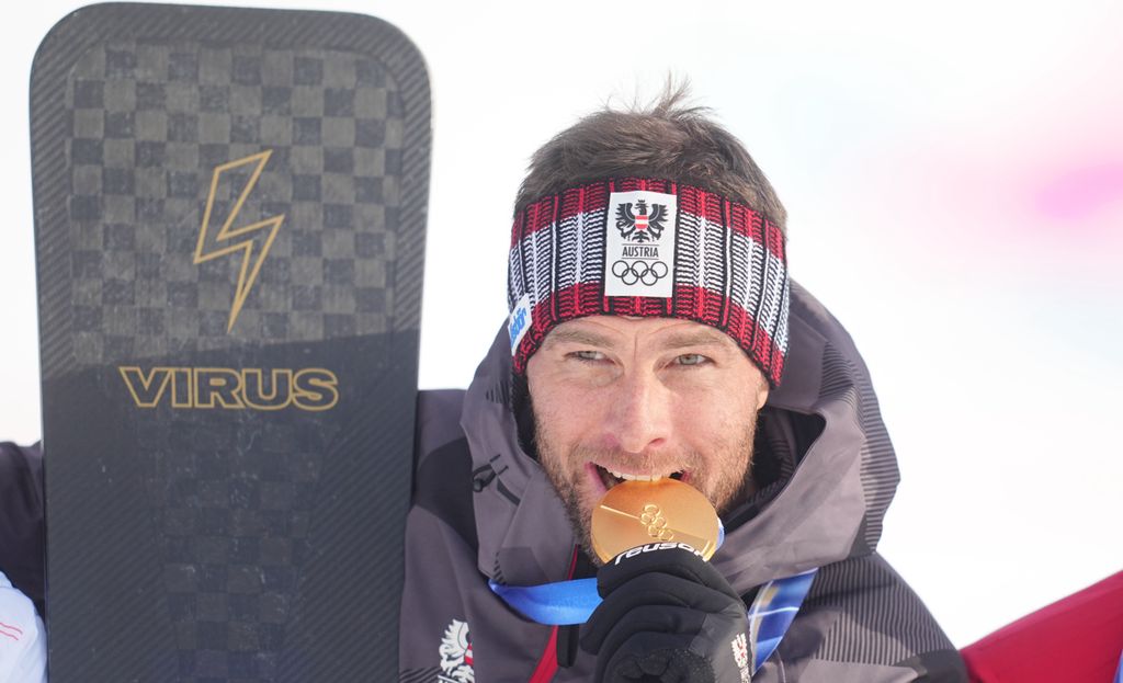 Benjamin Karl muerde su medalla de oro tras proclamarse campeón en el parallel giant slalom de snowboard durante los Juegos Olímpicos de Invierno Milán-Cortina 2026, en Livigno