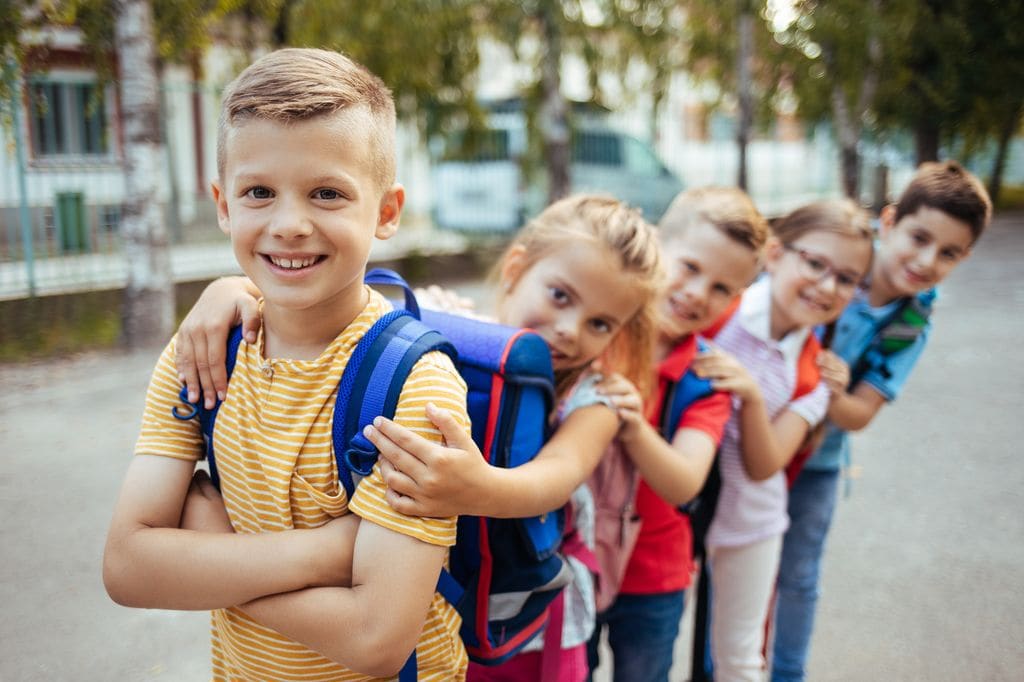 Grupo de amigos con la mochilas en la vuelta al colegio