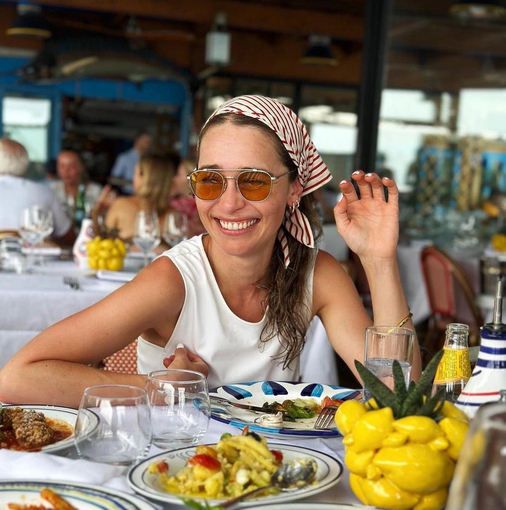 Emilia Clarke frente a una mesa con comida,
