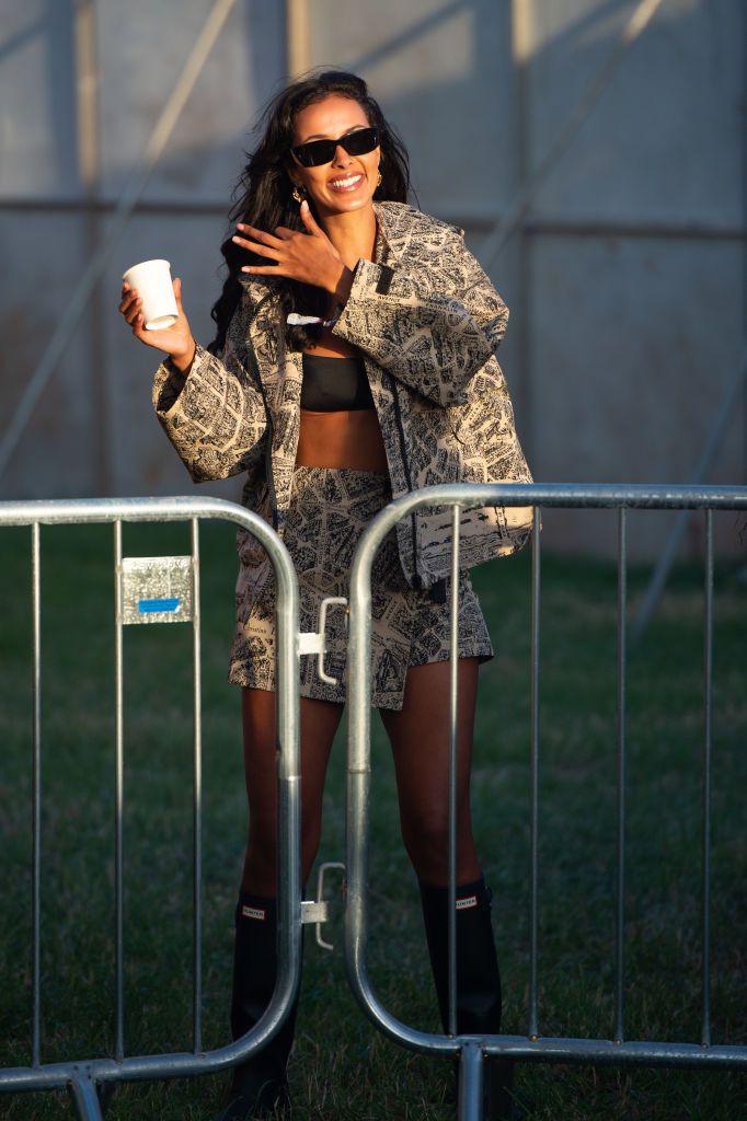 Maya Jama apuesta por un set estampado firmado por Dior, lo combina con un par de botas de lluvia largas y gafas oscuras. 
