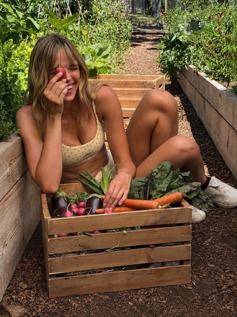 Mujer con una caja llena de verduras frescas