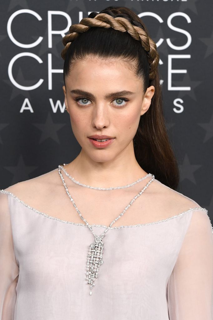 Margaret Qualley lleva una corona trenzada a su forma para una alfombra roja.