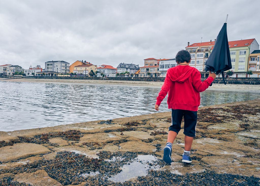 Niño jugando con la lluvia en Galicia 