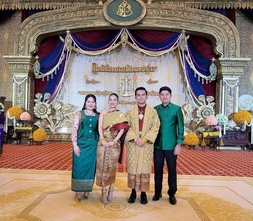 Los novios con modelos nupciales camboyanos posando con algunos invitados