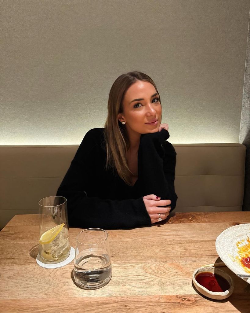 Plano medio de Alice Campello posando en un restaurante con jersey negro