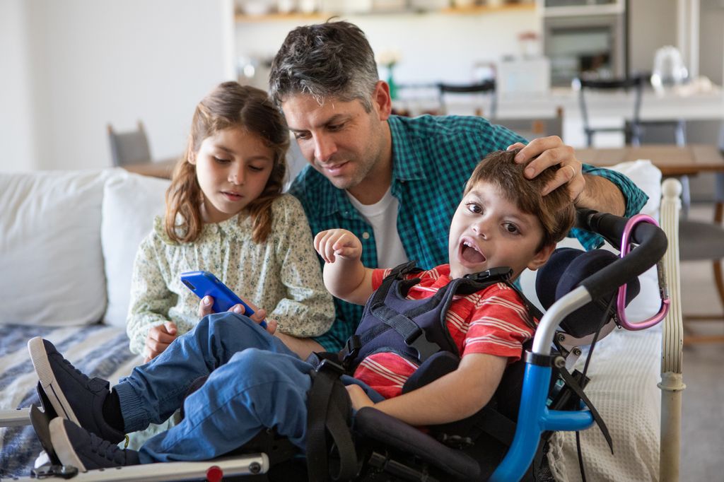 Padre con sus dos hijos, uno de ellos con discapacidad