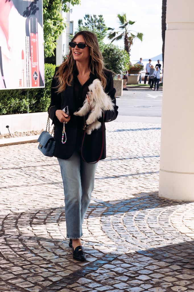 La modelo lució un blazer negro con blusa a juego y jeans claros, acompañados por gafas de sol, un bolso Chanel 11.12 Washed Denim y mocasines Christian Louboutin Penny Donna.