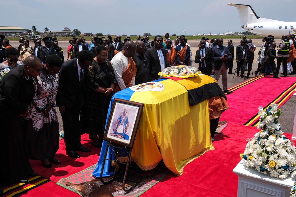 Representantes del Gobierno de Uganda rinden sus últimos respetos ante los restos mortales del rey Oyo Rukidi IV a su llegada al aeropuerto de Entebbe
