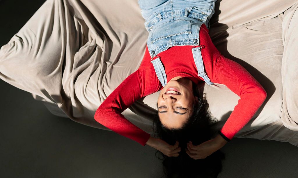 attractive young woman lies on the sofa at home while spending time with her alone quiet scene
