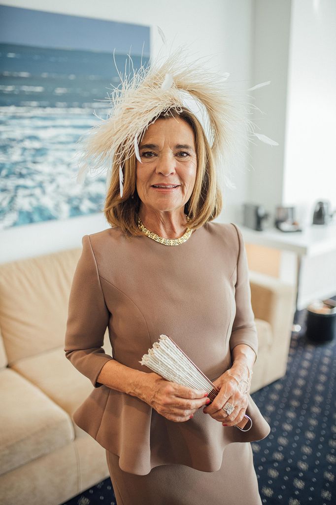 Madrina de boda con estilo con vestido de Poydel marrón