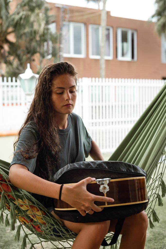 Una mujer sacando su guitarra