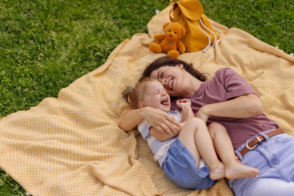 madre e hija disfrutando tumbadas sobre la hierba
